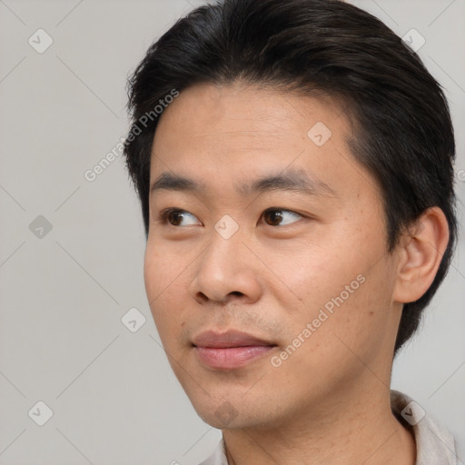 Joyful asian young-adult male with short  brown hair and brown eyes