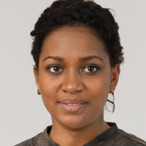 Joyful black young-adult female with short  black hair and brown eyes