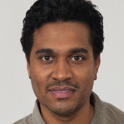 Joyful black young-adult male with short  black hair and brown eyes