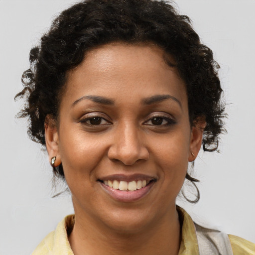 Joyful black young-adult female with short  brown hair and brown eyes