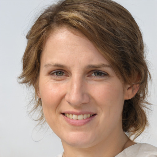 Joyful white adult female with medium  brown hair and brown eyes