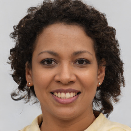 Joyful black young-adult female with medium  brown hair and brown eyes