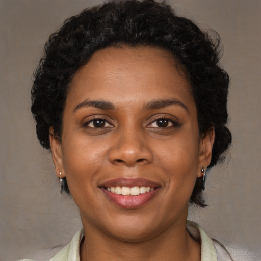 Joyful black young-adult female with medium  brown hair and brown eyes