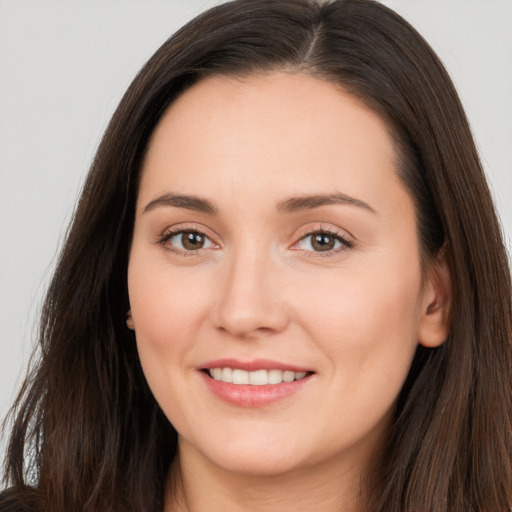 Joyful white young-adult female with long  brown hair and brown eyes