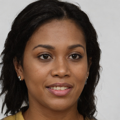 Joyful black young-adult female with long  brown hair and brown eyes