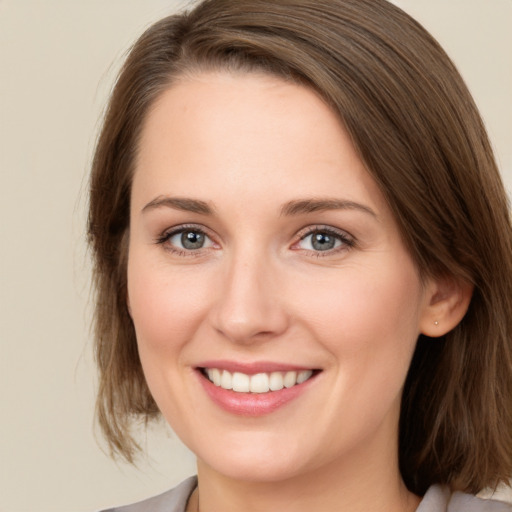 Joyful white young-adult female with medium  brown hair and green eyes