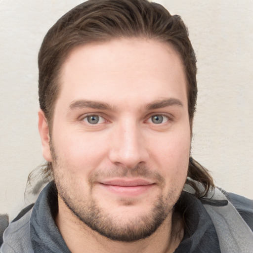 Joyful white young-adult male with short  brown hair and grey eyes