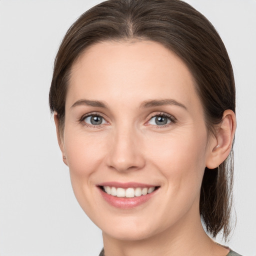 Joyful white young-adult female with medium  brown hair and grey eyes