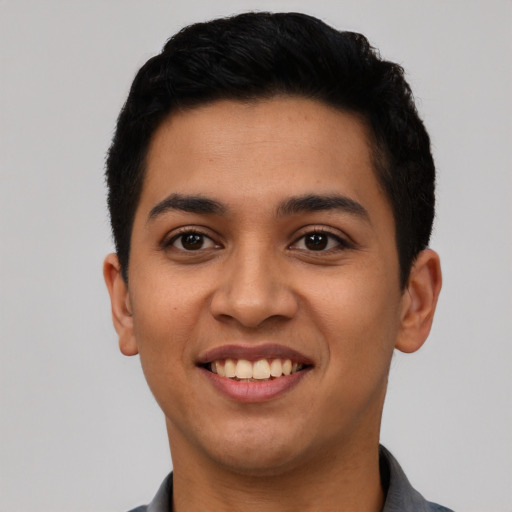 Joyful latino young-adult male with short  black hair and brown eyes