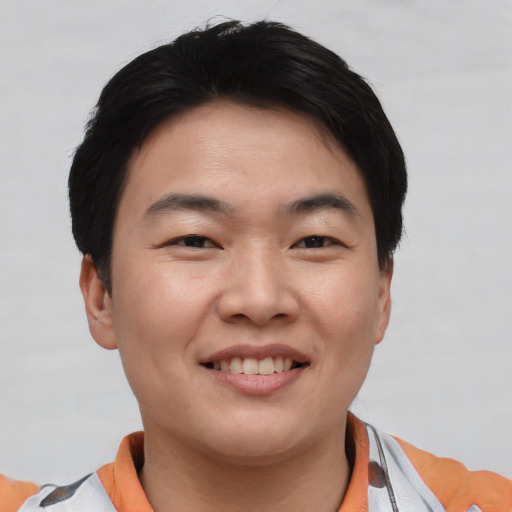 Joyful asian young-adult male with short  black hair and brown eyes