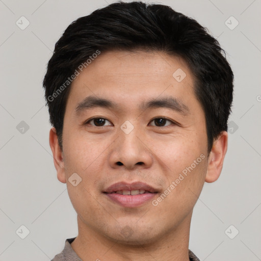 Joyful asian young-adult male with short  black hair and brown eyes