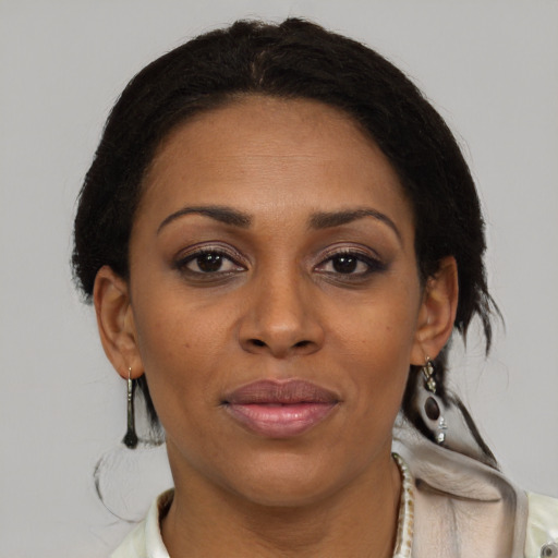 Joyful black adult female with medium  brown hair and brown eyes