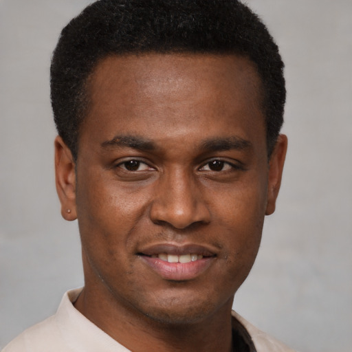 Joyful black young-adult male with short  brown hair and brown eyes
