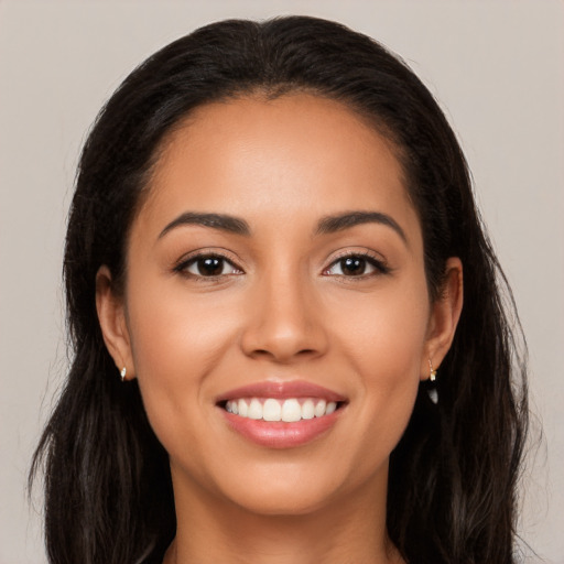 Joyful latino young-adult female with long  brown hair and brown eyes