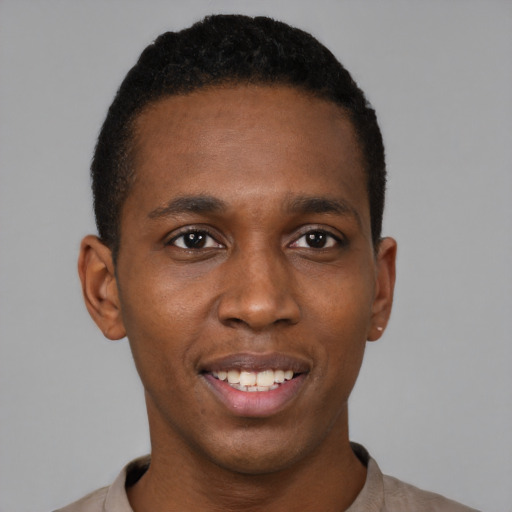 Joyful black young-adult male with short  black hair and brown eyes