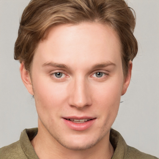 Joyful white young-adult male with short  brown hair and blue eyes