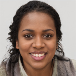 Joyful black young-adult female with long  brown hair and brown eyes