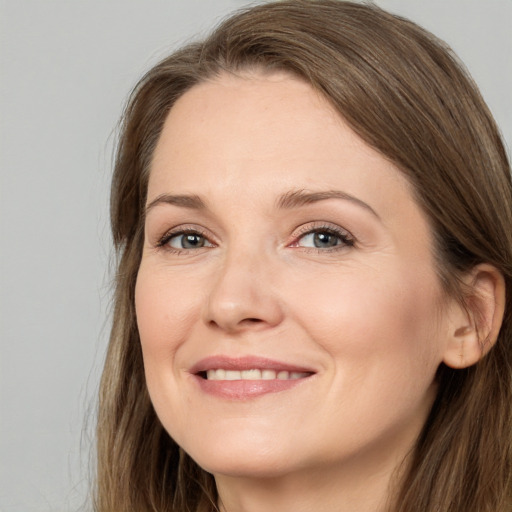 Joyful white adult female with long  brown hair and grey eyes