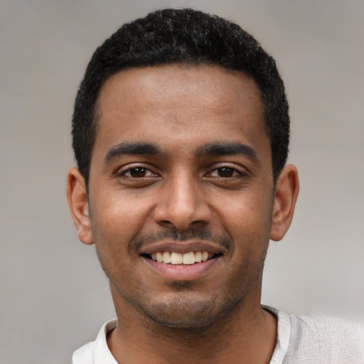 Joyful black young-adult male with short  black hair and brown eyes