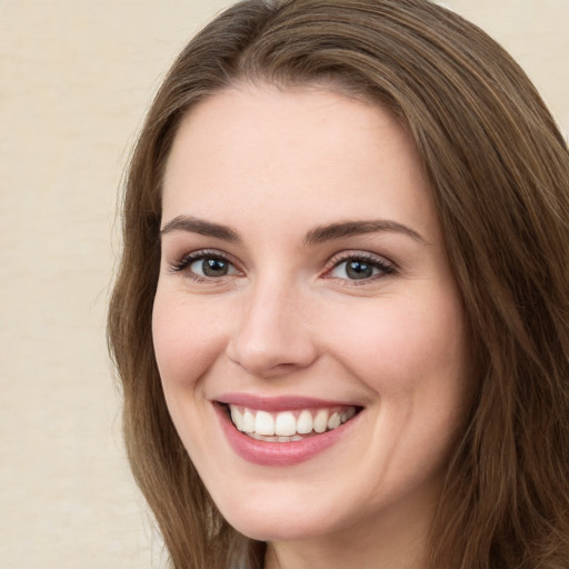 Joyful white young-adult female with long  brown hair and green eyes