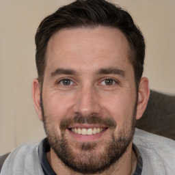 Joyful white adult male with short  brown hair and brown eyes