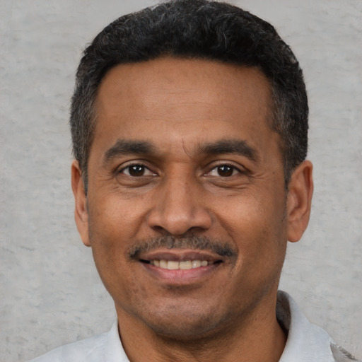 Joyful latino adult male with short  black hair and brown eyes
