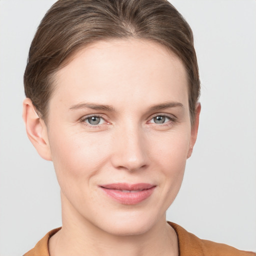 Joyful white young-adult female with short  brown hair and grey eyes