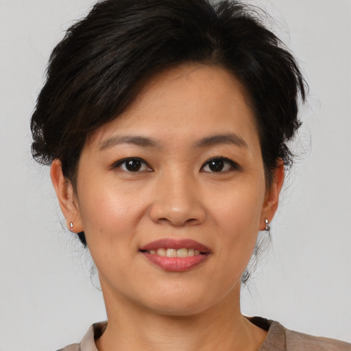 Joyful asian young-adult female with short  brown hair and brown eyes