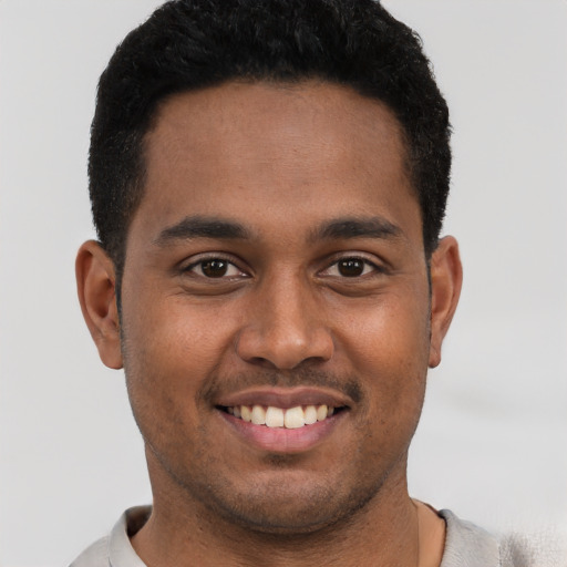 Joyful black young-adult male with short  brown hair and brown eyes