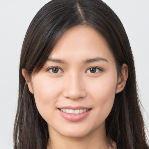 Joyful white young-adult female with long  brown hair and brown eyes