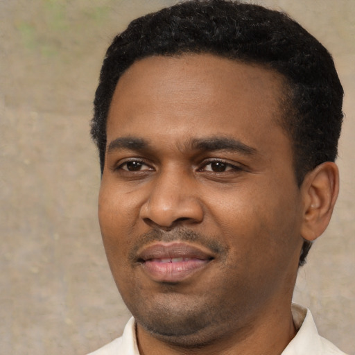 Joyful black young-adult male with short  black hair and brown eyes