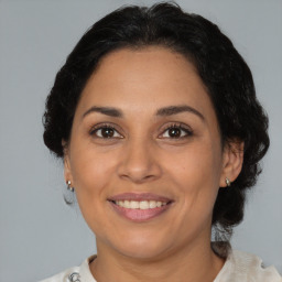 Joyful latino adult female with medium  brown hair and brown eyes