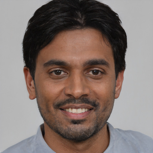 Joyful black young-adult male with short  black hair and brown eyes