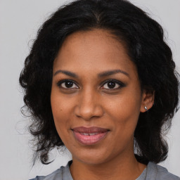 Joyful black adult female with medium  brown hair and brown eyes