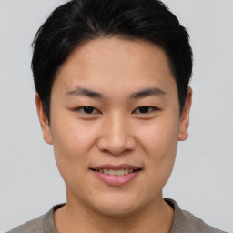 Joyful asian young-adult male with short  brown hair and brown eyes