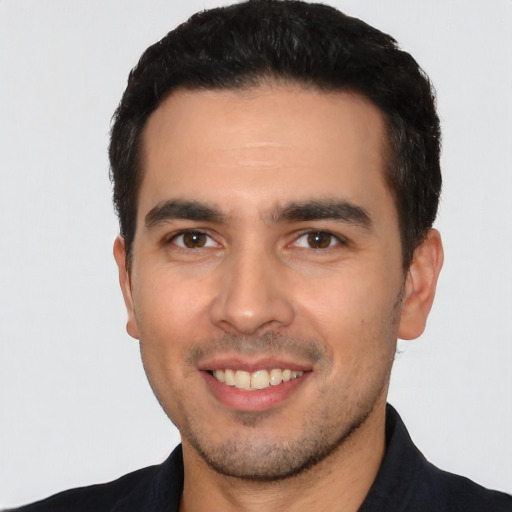 Joyful white young-adult male with short  black hair and brown eyes
