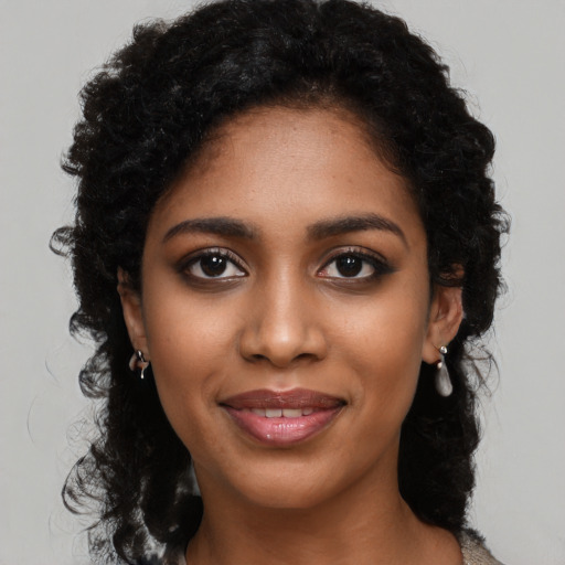 Joyful black young-adult female with long  black hair and brown eyes