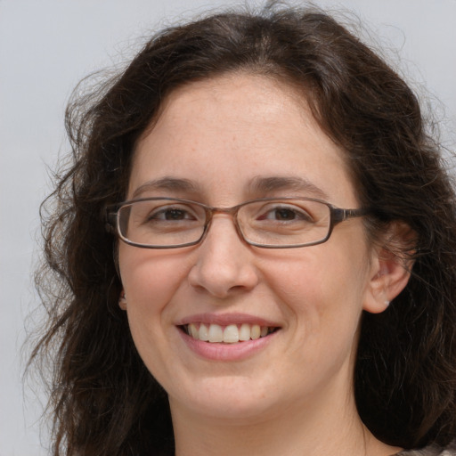 Joyful white adult female with long  brown hair and grey eyes