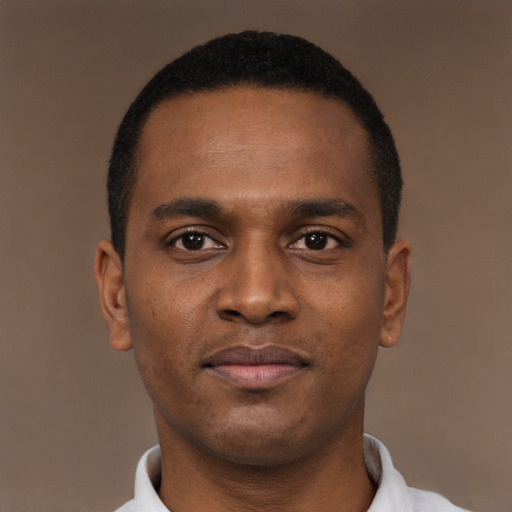 Joyful black young-adult male with short  brown hair and brown eyes