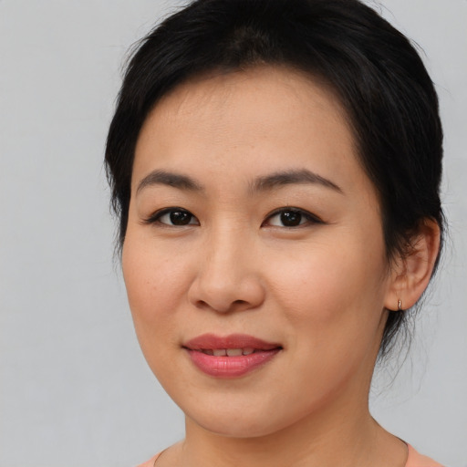 Joyful asian young-adult female with medium  brown hair and brown eyes