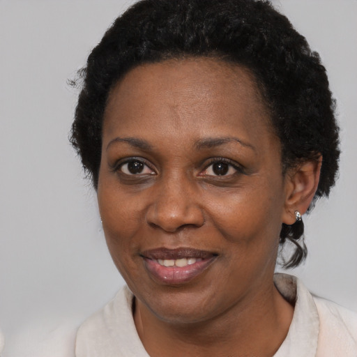 Joyful black adult female with short  black hair and brown eyes