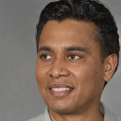 Joyful black adult male with short  black hair and brown eyes