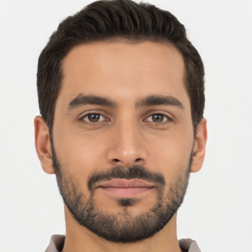 Joyful latino young-adult male with short  brown hair and brown eyes