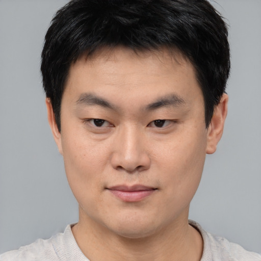 Joyful asian young-adult male with short  black hair and brown eyes