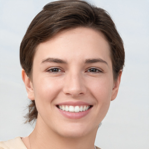 Joyful white young-adult female with short  brown hair and grey eyes