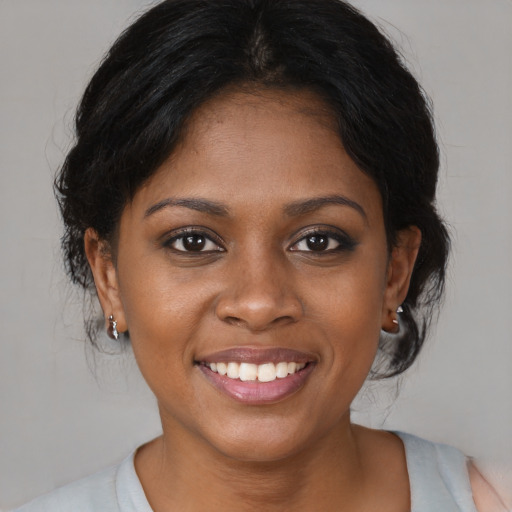 Joyful black young-adult female with medium  brown hair and brown eyes