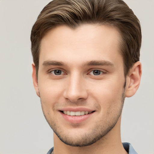 Joyful white young-adult male with short  brown hair and grey eyes