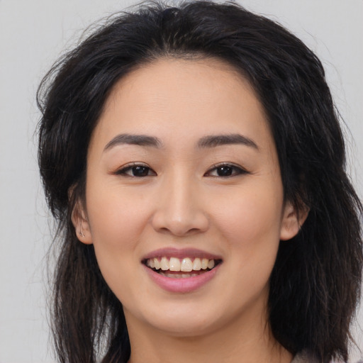 Joyful asian young-adult female with long  brown hair and brown eyes