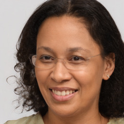 Joyful black adult female with medium  brown hair and brown eyes