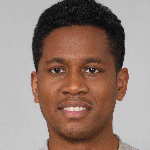 Joyful black young-adult male with short  brown hair and brown eyes